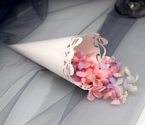 Macro detail of white laser-cut wedding petal cone with intricate lace hollow patterns