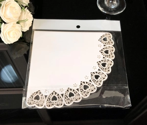 Detail of white laser-cut lace paper with heart patterns in plastic packaging