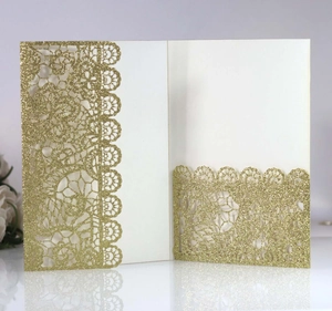 Detail of laser-cut glitter wedding invitation with intricate lace floral patterns