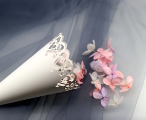 Detailed laser-cut heart pattern on white lace wedding confetti cone for petals
