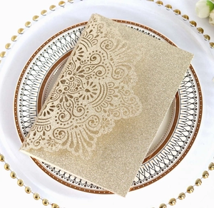 Detail of laser-cut gold glitter wedding invitation card on elegant porcelain plate