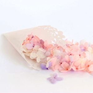 Laser-cut wedding confetti cones with colorful dried hydrangea petals on white background