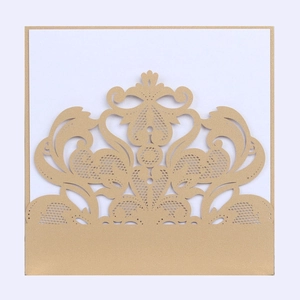 Detail of gold laser-cut lace wedding invitation with intricate baroque floral patterns