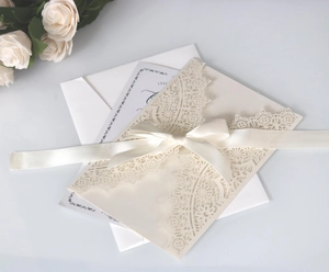 Detailed laser-cut wedding invitation set with ivory lace sleeve and elegant satin ribbon