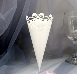 Close-up of white laser-cut wedding petal cone with delicate bow design and lace detail