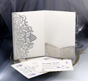 Detail of silver glitter laser cut wedding invitation set with floral cover and RSVP cards