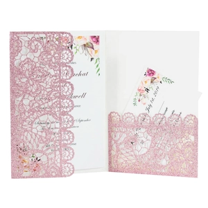 Detail of pink laser cut wedding invitation with glitter finish and rose floral pattern