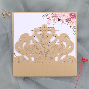 Detail of laser-cut gold lace invitation with watercolor floral inner card