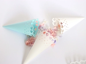 Detail of light blue and white lace paper cones with heart cutouts for wedding confetti