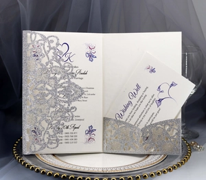 Detail of laser-cut silver glitter wedding invitation with elegant purple floral inserts
