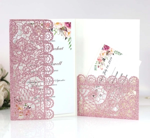 Detail of pink laser-cut lace wedding invitation with glitter floral envelope and RSVP card