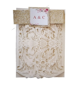 Detailed laser-cut rose pattern on ivory wedding invitation with gold glitter band