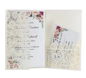 Detail of laser-cut lace wedding invitation with floral insert cards in cream white