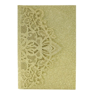 Close-up of laser-cut mandala lace patterns on golden glitter wedding invitation