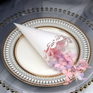 White lace paper wedding cone with bow and faux petals on a decorative gold-trimmed plate