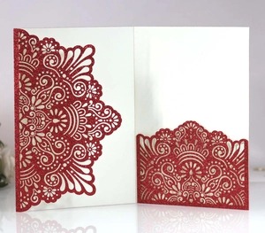 Detail of red glitter laser-cut invitation cover with intricate mandala hollow pattern