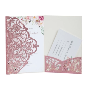 Close-up of rose gold glitter laser-cut lace wedding invitation with floral insert card