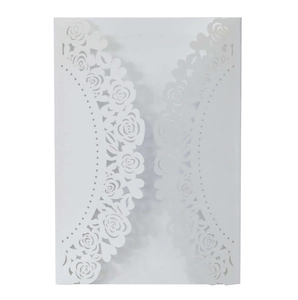 Macro view of laser-cut rose patterns on white wedding invitation card paper