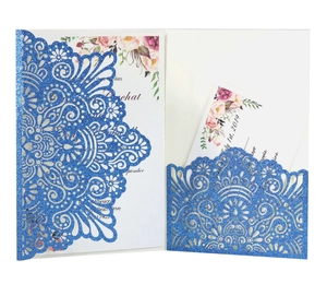 Macro view of blue glitter laser-cut mandala hollow wedding invitation with printed insert