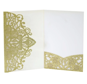 Macro shot of glittery gold laser-cut lace wedding invitation with floral hollow details