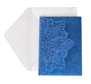 Detail of laser-cut blue glitter business invitation card with a white envelope
