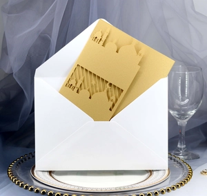 Laserschnitt-Hochzeitseinladung mit goldener Moschee-Silhouette und weißem Umschlag