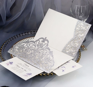 Detail of silver glitter laser cut wedding invitation with elegant lace pattern