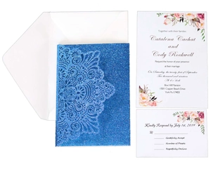 Detail of laser-cut glitter blue invitation set with floral inserts and white envelope