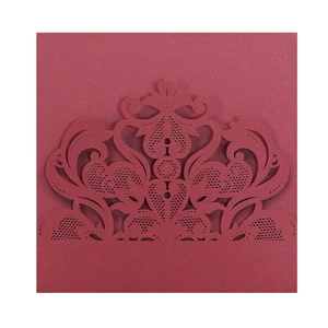 Detailed macro view of laser-cut burgundy lace invitation card with floral patterns