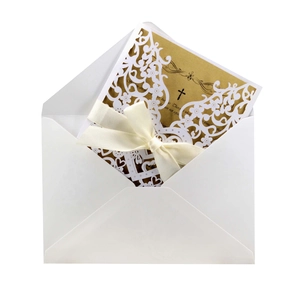 Detailed laser cut white floral wedding invitation with gold inner card and ribbon bow