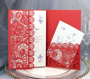 Macro detail of laser-cut red lace wedding invitation with elegant floral hollow patterns