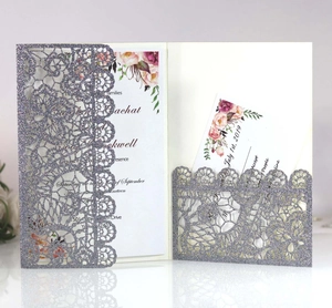 Detail of laser-cut wedding invitation with lace patterns and glitter finish