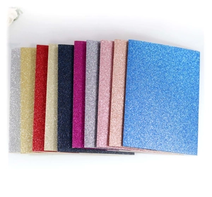 Close-up of vibrant glitter paper sheets in multiple colors for DIY wedding cards