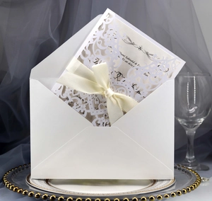 Elegant white laser cut wedding invitation with cream silk ribbon and envelope set