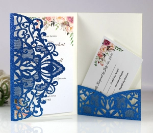 Close-up of laser-cut blue glitter wedding invitation with intricate floral lace pattern
