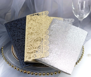 Detail of laser-cut glitter wedding invitations in royal blue, gold, and silver finishes