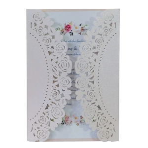 Close-up of laser cut rose floral hollow design on white pearlescent wedding invitation