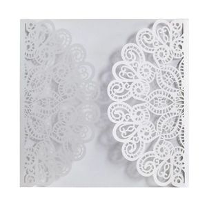 Close-up of elegant laser-cut peacock lace pattern on white wedding invitation card
