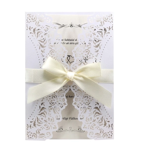 Laser cut white wedding invitation with beige inner sheet and cream satin ribbon bow