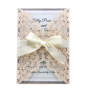 Close-up of laser-cut floral pattern with silk ribbon on pink wedding invitation