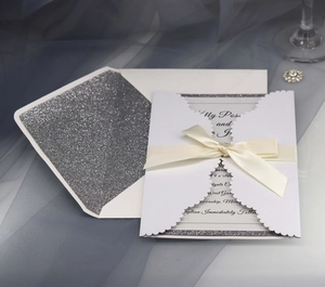Lace wedding invitation with ribbon and silver glitter lined envelope on blue tulle
