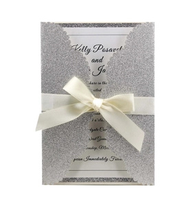 Silver laser cut wedding invitation with glitter finish and elegant white satin bow