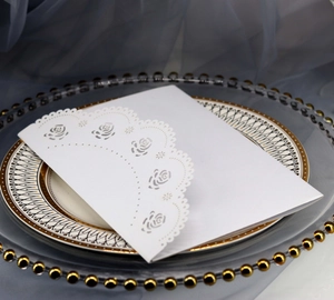 Détails de motifs floraux de roses découpés au laser sur une carte d'invitation blanche élégante