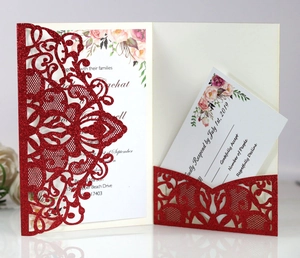 Detail of red glitter laser-cut wedding invitation with lace floral design and RSVP card