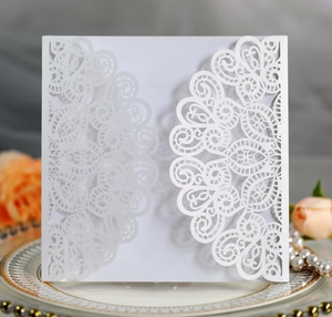 Intricate laser-cut white gatefold wedding invitation with elegant mandala lace patterns