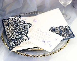 Detail of laser-cut glitter navy blue wedding invitations with elegant white insert cards