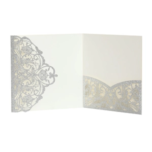 Detailed macro view of laser-cut ivory wedding invitation with silver glitter finish