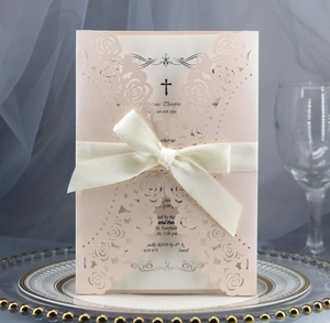 Detail view of laser-cut rose wedding invitation with pearl pink texture and silk ribbon bow