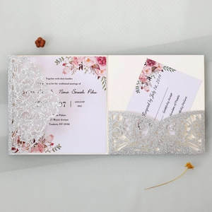 Detailed view of silver glitter laser-cut wedding invitation with pink floral inner cards