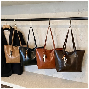 Detail view of large retro tote bags in brown, black, and coffee with beaded ornaments